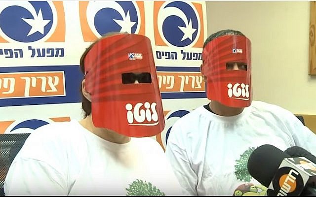 An Israeli couple keep their identities hidden as they collect their lottery winnings in May 2013  (YouTube screen shot)