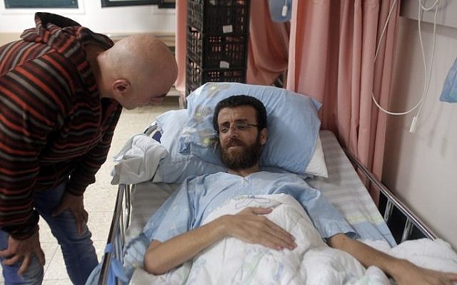 Mohammed al-Qiq, a Palestinian prisoner who carried out hunger strike, talks to a man in a hospital in the northern Israeli town of Afula on February 5, 2016. (Ahmad Gharabli/AFP)