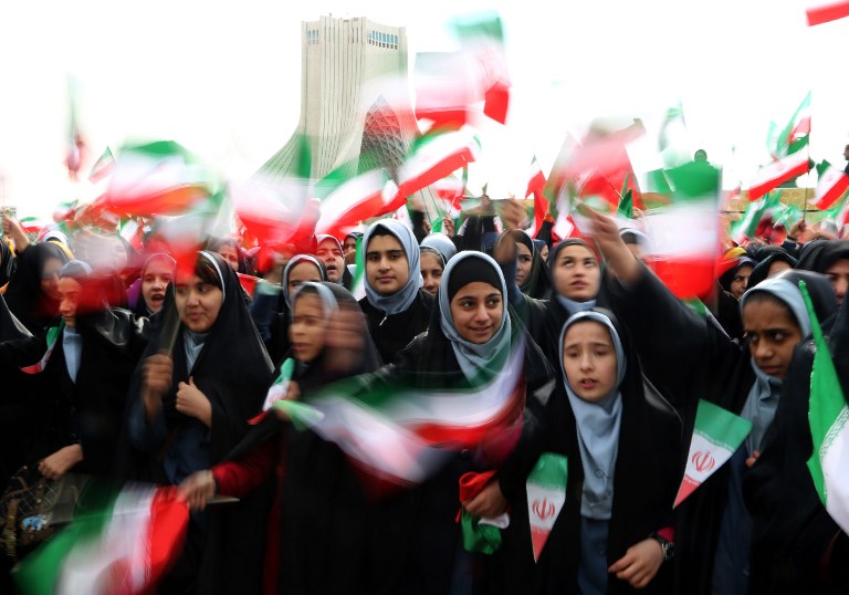 Iranian schoolgirls wave their national flag during celebrations in Tehran's Azadi Square (Freedom Square) to mark the 37th anniversary of the Islamic revolution on February 11, 2016. (Atta Kenare/AFP)