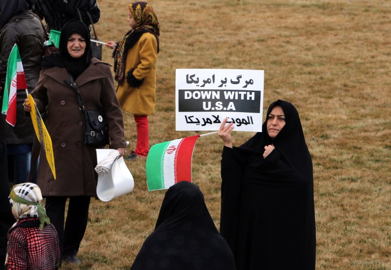 An Iranian woman holds an anti-US slogan during celebrations in Tehran's Azadi Square (Freedom Square) to mark the 37th anniversary of the Islamic revolution on February 11, 2016. (Atta Kenare/AFP)