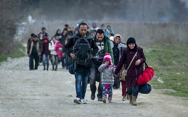 Migrants and refugees from Syria and Iraq cross the Greek-Macedonian border near the town of Gevgelija on February 23, 2016. (Robert Atanasovski/AFP)