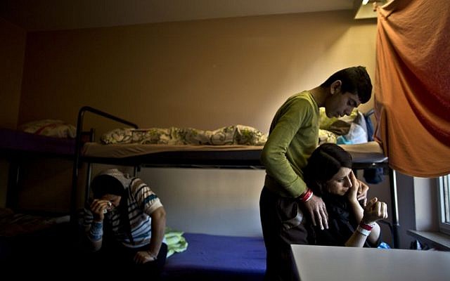 Delphine Qasu, 18, right, a Yazidi refugee from Sinjar, Iraq, is comforted by her brother Dilshad, 17, while crying after talking about their journey to reach Germany, at their new temporary home at Patrick Henry Village, in Heidelberg, Germany, Thursday, December 10, 2015 (AP Photo/Muhammed Muheisen)