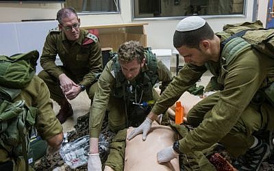 Col. Dr. Hagay Frenkel (center, red beret) watches as a team of IDF medical personnel treat their 'patients,' smart dolls that mimics the human respiratory and circulatory systems, in the Medical Simulation Center at Tel Hashomer Hospital in Ramat Gan on February 11, 2016. (Adi Brown/IDF Spokesperson's Unit)