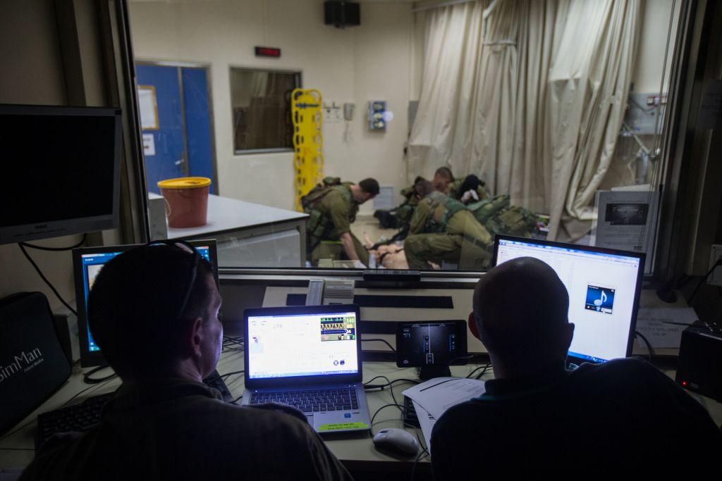 Operators watch from a control room as IDF medical personnel treat their 'patients,' smart dolls that mimics the human respiratory and circulatory systems, in the Medical Simulation Center at Tel Hashomer Hospital in Ramat Gan on February 11, 2016. (Adi Brown/IDF Spokesperson's Unit)