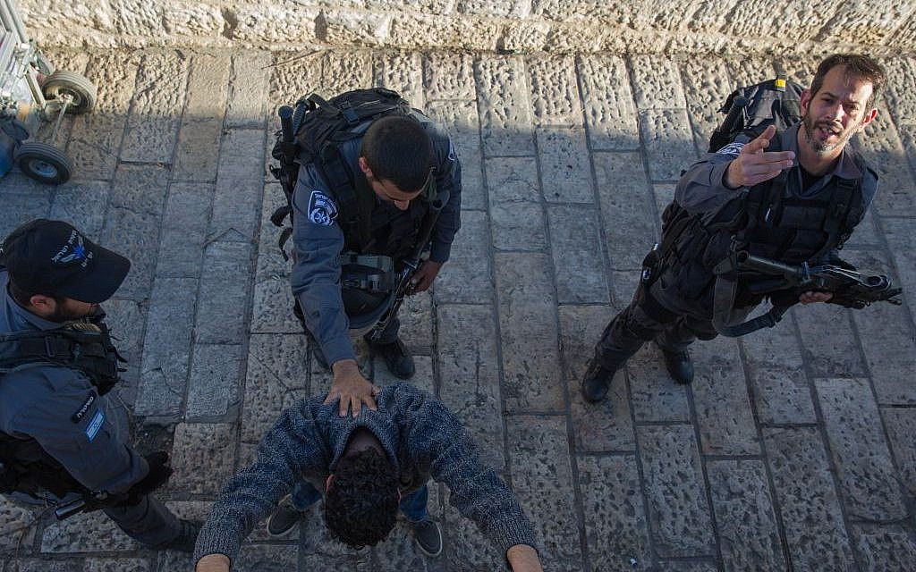 Illustrative: Israeli police officers search a Palestinian man at Damascus Gate in Jerusalem on February 15, 2016. (Nati Shohat/Flash90)