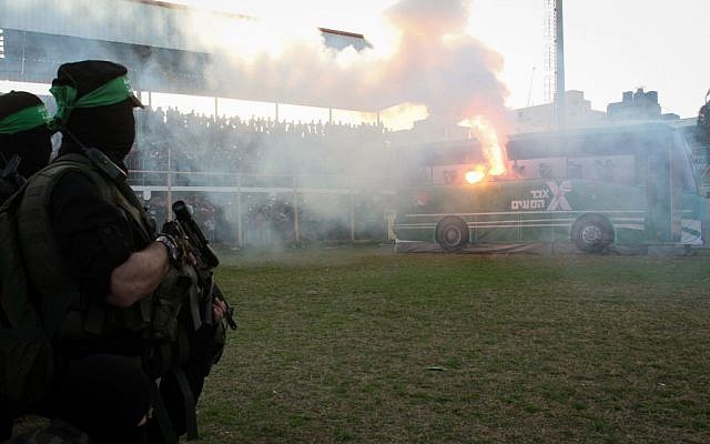 Hamas fighters look at a mockup of an Israeli bus on fire during a rally on February 26, 2016 in the southern Gaza Strip town of Rafah. (Abed Rahim Khatib/Flash90)