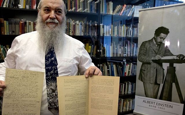 Hebrew University's Roni Gross holds the original historical documents related to Albert Einstein's prediction of the existence of gravitational waves at Hebrew University in Jerusalem, Thursday, Feb. 11, 2016. In a blockbuster announcement, scientists said Thursday that after decades of trying, they have detected gravitational waves, the ripples in the fabric of space-time that Einstein predicted a century ago. (AP Photo/Sebastian Scheiner)