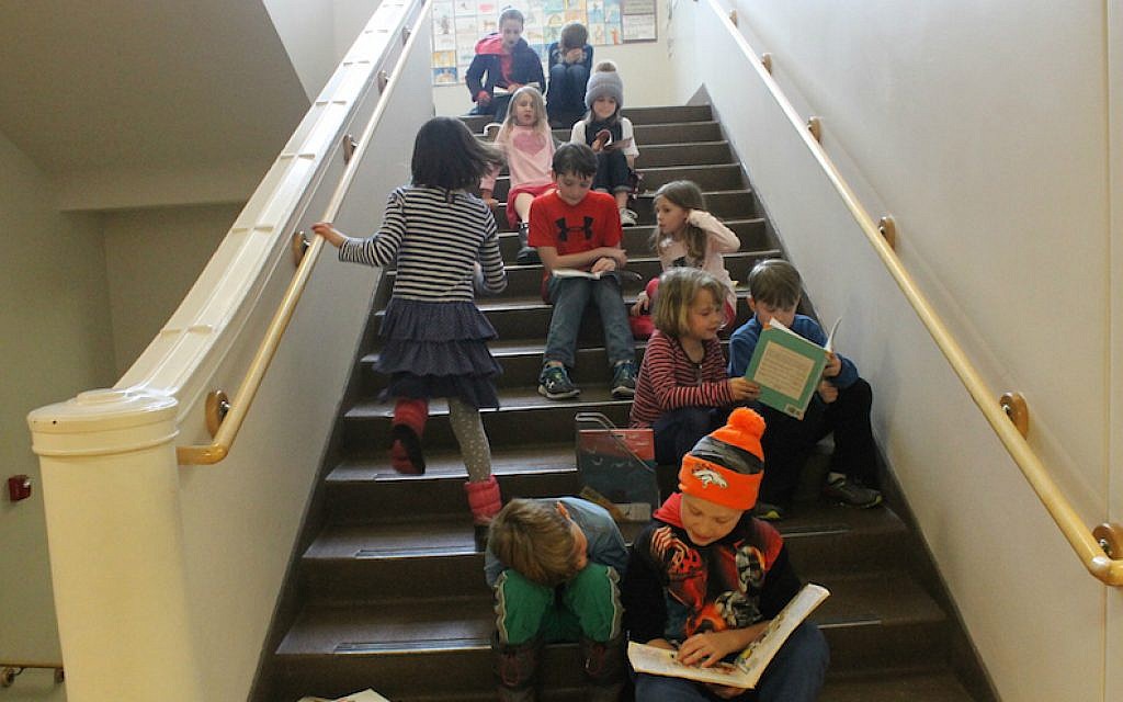 The older students take time out of the day to read stories to younger students at the McGillis School in Salt Lake City, Utah. (Uriel Heilman/JTA)