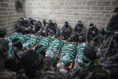 Palestinian fighters from the Izz ad-Din al-Qassam Brigades pray near the bodies of seven colleagues killed while repairing a tunnel, during their funeral at a mosque in Gaza City, on January 29, 2016. (Emad Nassar/Flash90)