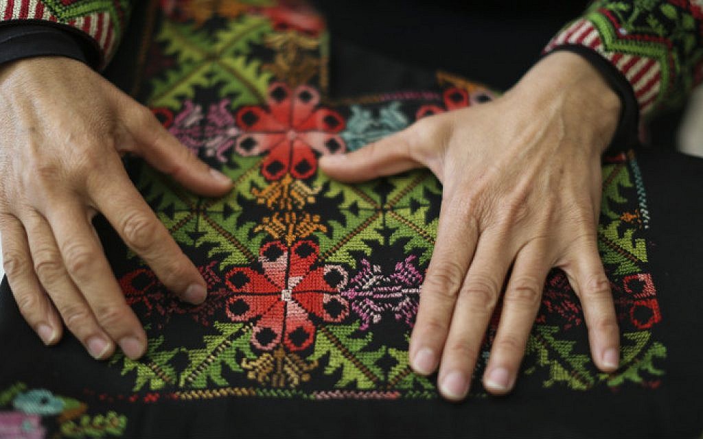 In this illustrative photo, a Bedouin woman shows crafts created by women at 'Desert Embroidery: Association for the Improvement of the Woman,' in the Bedouin city of Lakiya, on April 1, 2014. (Hadas Parush/Flash 90)