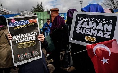 A Zaman supporter reads the latest edition of the Turkish daily newspaper in front of the newspaper's headquarters in Istanbul on March 5, 2016, after Turkish authorities seized the headquarters in a midnight raid. (AFP/Ozan Kose)