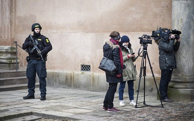 A Danish policeman looks at journalists as he stands guard in front of the city court in Copenhagen, Denmark, during a trial against four men accused of helping a Danish-born gunman attack a synagogue, March 10, 2016. (AFP/Scanpix Denmark/Emil Hougaard/Denmark OUT)