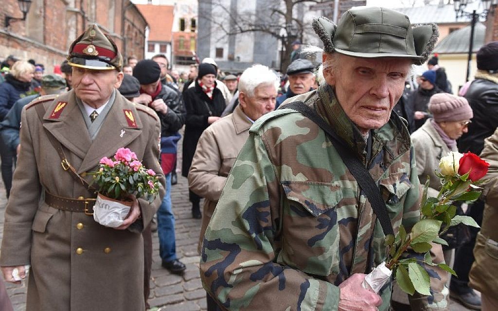 Veterans of the Latvian Legion, a force that was commanded by the German Nazi Waffen SS during WWII, and their sympathizers carry flowers as they walk to the Monument of Freedom in Riga, Latvia on March 16, 2016 to commemorate a key 1944 battle in their ultimately failed attempt to stem a Soviet advance. (AFP/ Ilmars Znotins)