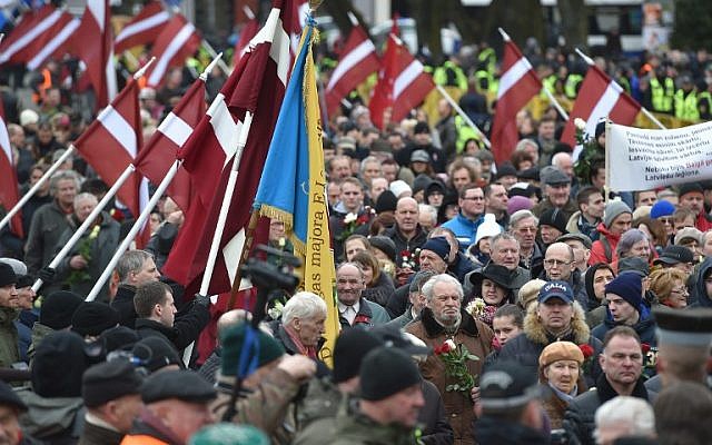 Veterans of the Latvian Legion, a force that was commanded by the German Nazi Waffen SS during WWII, and their sympathizers carry flowers as they walk to the Monument of Freedom in Riga, Latvia, March 16, 2016. (AFP/Ilmars Znotins)