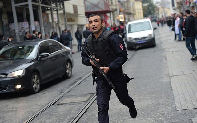 A Turkish policeman runs after an explosion on the pedestrian Istiklal avenue in Istanbul on March 19, 2016. (AFP / Bulent KILIC)