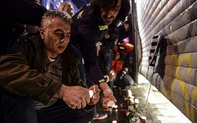 People light candles at the site of a blast on Istiklal Street, a major shopping and tourist district, in central Istanbul on March 19, 2016. A suicide blast ripped through Istanbul, killing three Israelis and one Iranian less than a week after another deadly attack left 35 dead in Ankara. (AFP / BULENT KILIC)