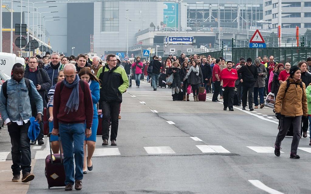People walk away from Brussels airport after explosions rocked the facility in Brussels, Belgium, March 22, 2016. (AP/Geert Vanden Wijngaert)