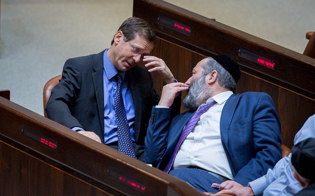 Zionist Union leader Isaac Herzog (L) talks to Shas party leader Aryeh Deri in the Knesset plenum on May 4, 2015 (Miriam Alster/Flash90)