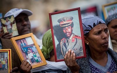 Israelis who immigrated from Ethiopia hold up family photos of loved ones who remain in Ethiopia during a protest to bring the rest of the Falashmura in Jerusalem, on March 20, 2016. (Yonatan Sindel/Flash90)