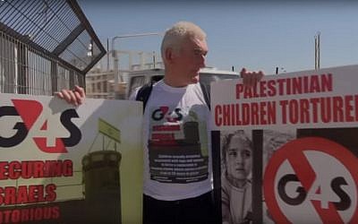 A protester holds posters against the G4S security company outside Israel's Ofer Prison in May 2013 (screen capture: YouTube)