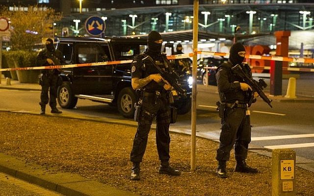 Dutch policemen stand guard by a cordoned off area outside Amsterdam's Schiphol Airport late on April 12, 2016, after it was partially evacuated following a security alert, and a person was one arrested, according to official sources. (AFP/ ANP / Michel van Bergen)