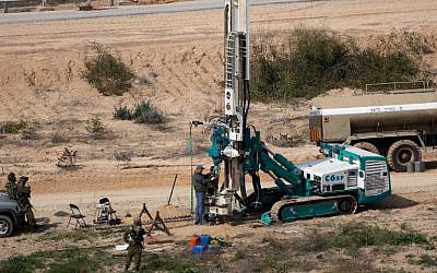 This February 10, 2016, file photo shows IDF soldiers keeping watch as a machine drills holes in the ground on the Israeli side of the border with the Gaza Strip as they search for tunnels used by Palestinian terrorists planning to attack Israel. (AFP/Menahem Kahana)