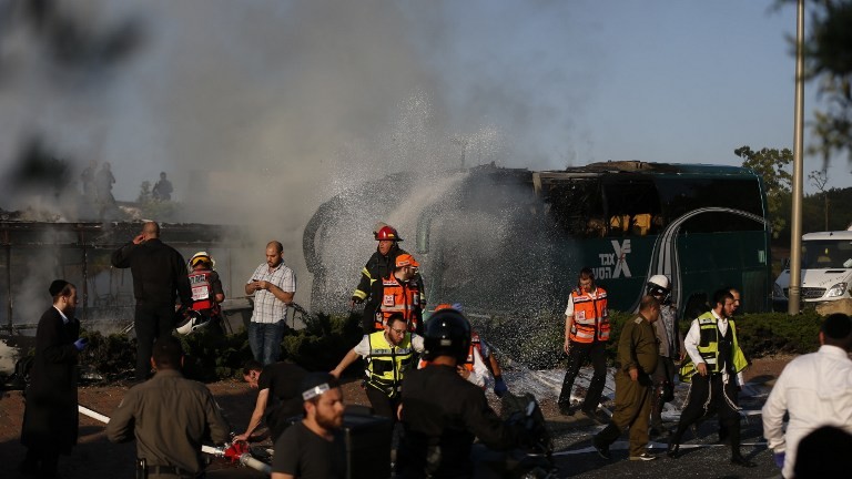 Israeli forensic and firefighters work at the scene of an explosion on a bus in Jerusalem on April 18, 2016. (AFP PHOTO / AHMAD GHARABLI)