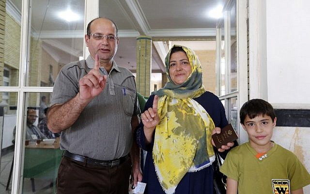 Iranian family members display their ink-stained fingers after casting their ballot to vote in the second round of parliamentary elections at a polling station in the town of Robat Karim, some 40 kms southwest of the capital Tehran, on April 29, 2016. (AFP/Atta Kenare)