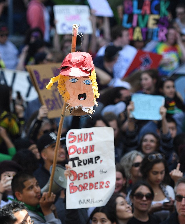 The head of a Donald Trump pinata is held at the end of a stick during a protest outside the Hyatt Regency Hotel where The US Republican presidential candidate was speaking in Burlingame, California on April 29, 2016. (AFP/Josh Edelson)