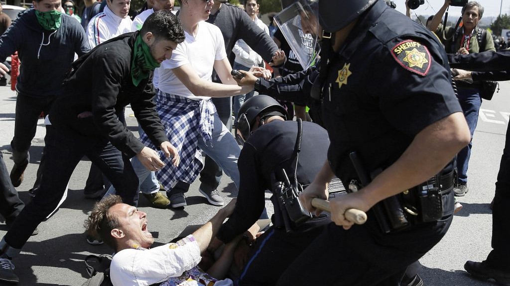 Police officers take a man into custody who was protesting Republican presidential candidate Donald Trump outside of the Hyatt Regency hotel during the California Republican Party 2016 Convention in Burlingame, Calif., Friday, April 29, 2016. (AP Photo/Eric Risberg)