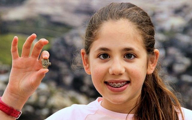 This image released by the Ir David Foundation - City of David on Tuesday, April 19, 2016 shows Neshama Spielman with an ancient Egyptian amulet dating back more than 3,200 years to the days of the Pharaohs discovered by the 12-year-old Israeli girl. Spielman and her family took part in the Temple Mount Sifting Project, an initiative to sort through earth discarded from the area of the biblical temples in Jerusalem. (Adina Graham, Ir David Foundation - City of David via AP)