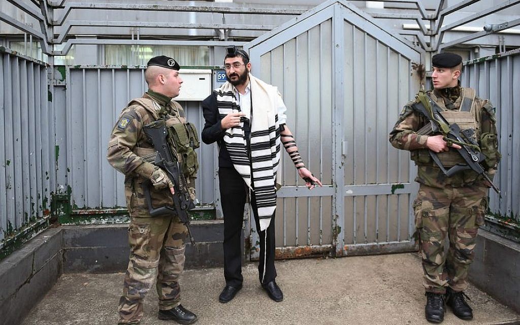 Illustrative: Soldiers guarding a staff member at a Chabad school in Paris, November 16, 2015. (Israel Bardugo/Courtesy of the International Fellowship of Christians and Jews/via JTA)