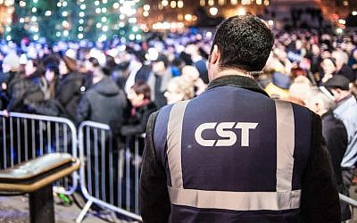 A Community Security Trust guard keeping watch over a Hanukkah celebration in London in 2014. (Blake Ezra Photography via JTA)