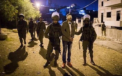 IDF soldiers arrest a Palestinian man in the Deheishe Refugee Camp, near the West Bank city of Bethlehem, on December 8, 2015. (Nati Shohat/Flash90)