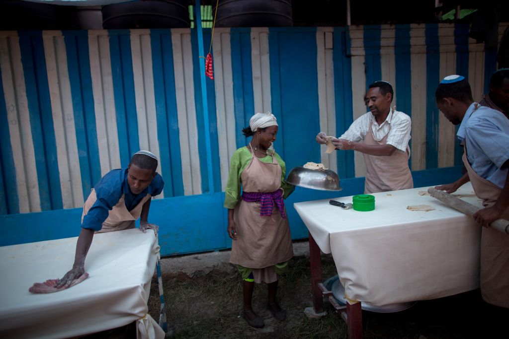 Members of Gondar's Jewish community prepare matzah before Passover on April 20, 2016. The matzah dough hand-off has to be done quickly and efficiently so that the matzah can be cooked in less than 18 minutes. (Miriam Alster/Flash90)