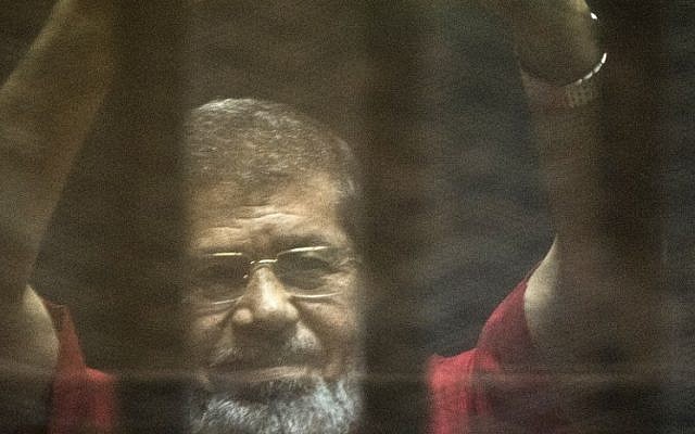 Egypt's ousted Islamist president Mohammed Morsi gestures from behind the defendant's bars during his trial at the police academy in Cairo on May 7, 2016. (AFP Photo/Khaled Desouki)