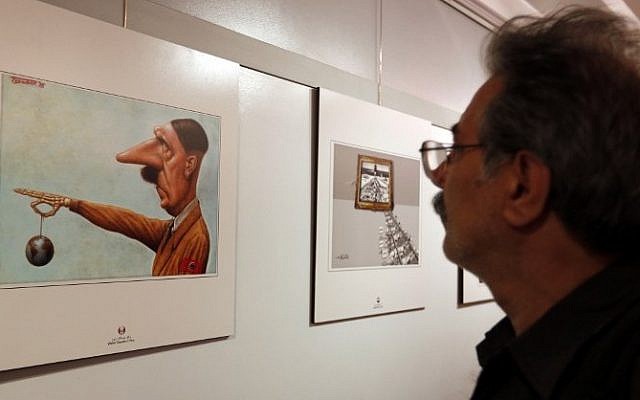 An Iranian man looks at a cartoon showing late German dictator Hilter at the second international exhibition of drawing and cartoons on the Holocaust in Tehran on May 14, 2016. (AFP / ATTA KENARE)