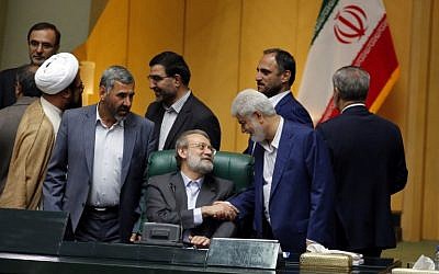 Iran's re-elected Parliament speaker Ali Larijani (C) is congratulated by MPs following the announcement of the results during a parliament session in Tehran on May 29, 2016. (AFP PHOTO / ATTA KENARE)