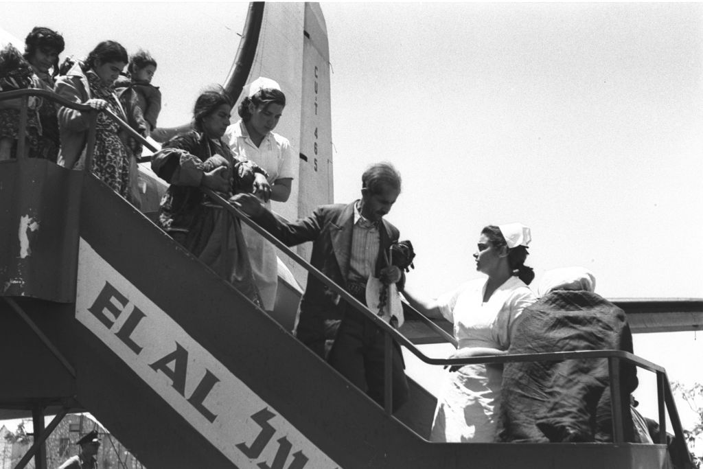 Immigrants from Iraq and Kurdistan exit their plane on arrival in Israel, having flown via Tehran, late spring 1951. Planes were arriving several times a day in this period, according to the original Government Press Office photo captions (Teddy Brauner, GPO)