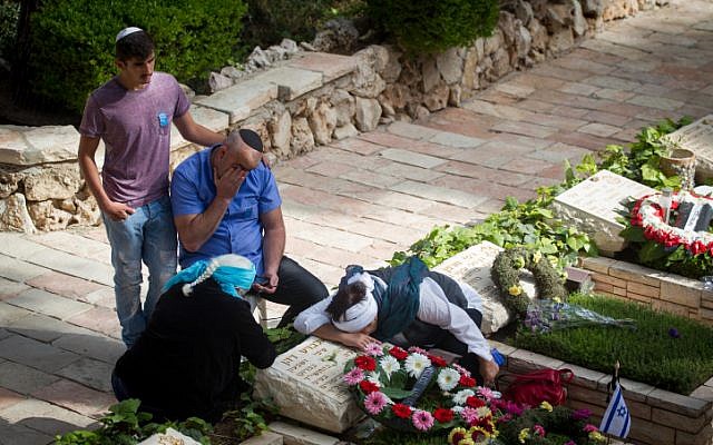 Bereaved Israelis mourn next to graves of fallen soldiers at the Mt. Herzl military cemetery in Jerusalem on Israeli Memorial Day. May 11, 2016. (Miriam Alster/Flash90)