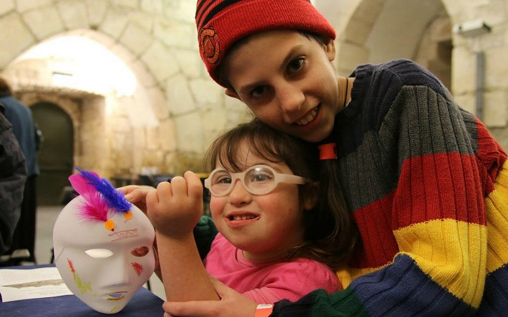 A brother hugs his sister at Tower of David Museum's Purim program for families with children with special needs, March 2016 (Ricky Rachman)