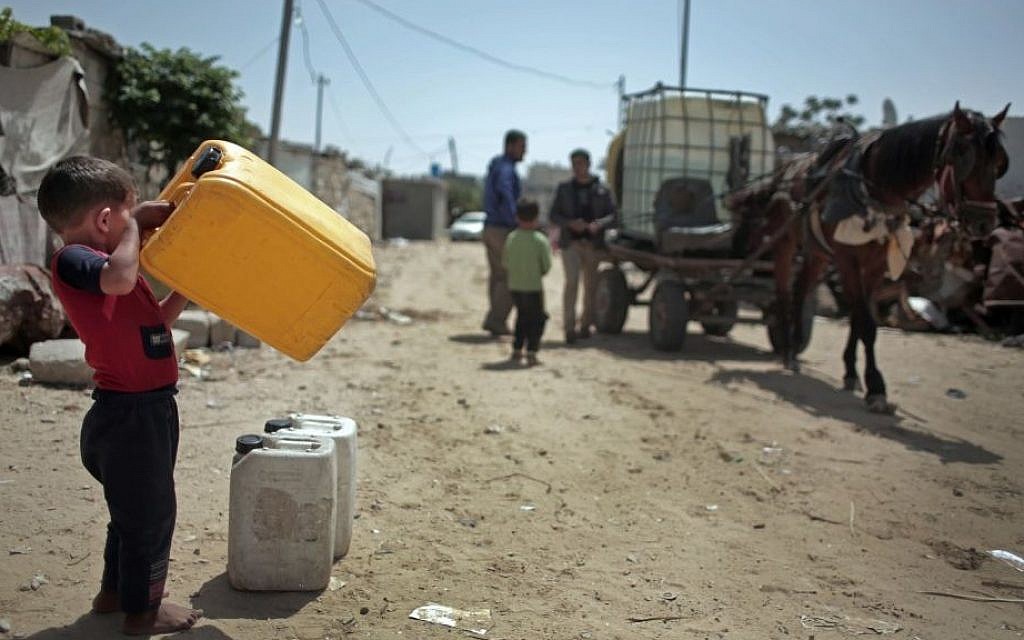 A Palestinian boy waits to fill plastic gallons with drinking water from a vendor in Khan Younis refugee camp, southern Gaza Strip, April 16, 2016. (AP Photo/Khalil Hamra)
