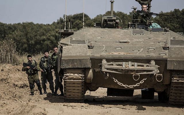 Israeli soldiers stand by a tank near the Israel Gaza border, Wednesday, May 4, 2016. (AP/Tsafrir Abayov)
