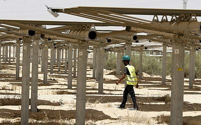 A worker walking past some of the 55,000 mirrors directing sunlight toward the Ashalim solar tower during construction, near the southern Israeli kibbutz of Ashalim in the Negev desert, May 26, 2016. (Jack Guez/AFP)
