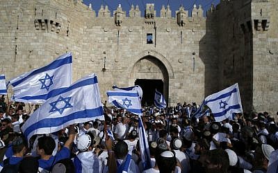 Israelis wave national flags as they take part in an annual march marking Israel's 1967 capture and subsequent annexation of the eastern half of Jerusalem, outside Damascus Gate in Jerusalem's Old City on June 5, 2016. (AFP PHOTO / AHMAD GHARABLI)