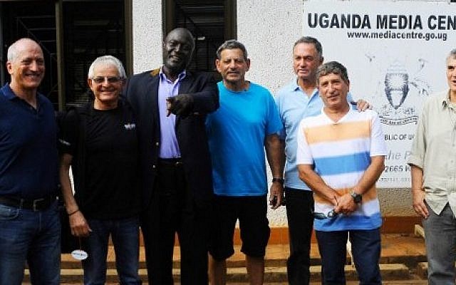 A picture taken on June 14, 2016 shows (LtoR) Eyal Oren, Shlomo Carmel, Jaffer Amin, Amjon Peled, Alex Davidi, unidentified, and Amir Ofer, members of the former IDF commandos and Entebbe hostages, posing in Kampala ahead of the 40th anniversary of their rescue. (AFP PHOTO / RONALD KABUUBI)