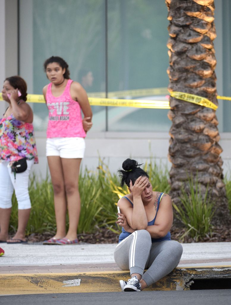 People wait outside the emergency entrance of the Orlando Regional Medical Center hospital after a shooting involving multiple fatalities at Pulse Orlando nightclub in Orlando, Fla., Sunday, June 12, 2016. (AP Photo/Phelan M. Ebenhack)