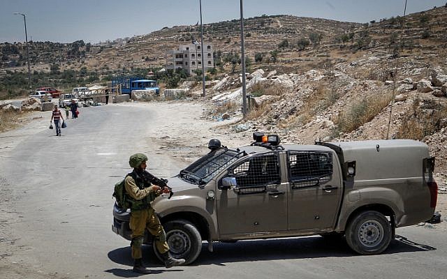Israeli soldiers man a checkpoint at the entrance to the Palestinian village of Yatta in the southern West Bank on June 9, 2016. (Wisam Hashlamoun/Flash90)