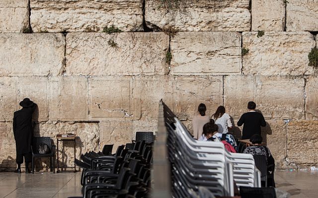 People pray on either side of the dividing wall that separates the male and female prayer sections at the Western Wall, June 14, 2016. (Wajsgras/Flash90)