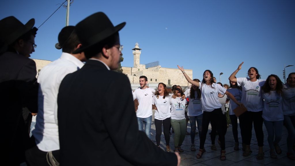 Ultra-Orthodox Jewish men yell and protest the Reform and Conservative Jewish men and women as they hold a prayer service in front of the Western Wall, in Jerusalem's Old City, on June 16, 2016. (Hadas Parush/Flash90)